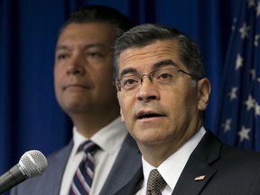 FILE - In this Sept. 5, 2017, file photo, California Attorney General Xavier Becerra, right, flanked by Secretary of State Alex Padilla during a news conference in Sacramento, Calif. Becerra is suing the Trump administration, saying the federal Department of Education is refusing to process debt relief claims from tens of thousands of students who had federal loans to attend Corinthian Colleges.