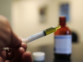 FILE - In this Nov. 6, 2017, file photo, a syringe loaded with a dose of CBD oil is shown in a research laboratory at Colorado State University in Fort Collins, Colo. A small-business owner in Idaho is currently fighting with local officials in the staunchly anti-marijuana state that he should be allowed to sell CBD oil.