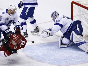 Tampa Bay Lightning goalie Andrei Vasilevskiy (88) makes a diving save on a shot as Arizona Coyotes center Clayton Keller (9) is checked to the ice by Lightning defenseman Dan Girardi (5) during the first period of an NHL hockey game, Thursday, Dec. 14, 2017, in Glendale, Ariz.