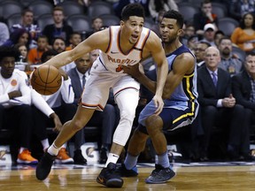 Back from injury, Phoenix Suns guard Devin Booker (1) dribbles past Memphis Grizzlies guard Andrew Harrison, right, during the first half of an NBA basketball game, Tuesday, Dec. 26, 2017, in Phoenix.
