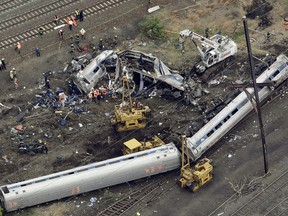 FILE - In this May 13, 2015, file photo, emergency personnel work at the scene of a derailment in Philadelphia of an Amtrak train headed to New York. Prosecutors are set to argue that criminal charges should be reinstated against the engineer in the deadly 2015 Amtrak derailment. Pennsylvania's attorney general on Wednesday, Dec. 20, 2017, is appealing a judge's decision to dismiss the case against Brandon Bostian.