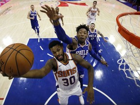 Phoenix Suns' Troy Daniels, left, goes up to shoot against Philadelphia 76ers' Robert Covington during the first half of an NBA basketball game, Monday, Dec. 4, 2017, in Philadelphia.