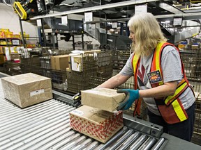 Canada Post employee at Edmonton processing facility. The federal government has decided not to let police search domestic mail, despite internal document indicating officials backed the change