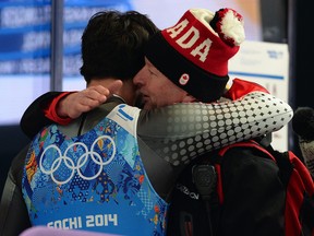 In this Feb. 13, 2014 file photo, Canada's Sam Edney (left) hugs a coach after placing fourth in the luge relay at the Sochi Olympics.