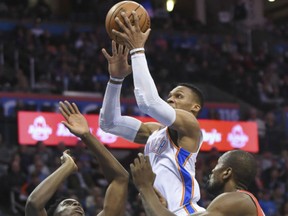 Oklahoma City Thunder's Russell Westbrook goes up for a shot over Toronto Raptors' OG Anunoby and Serge Ibaka in Oklahoma City, Wednesday.