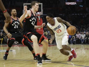 Lou Williams, right, of the Los Angeles Clippers moves the ball against defender Jakob Poeltl of the Toronto Raptors during NBA action Monday night in Los Angeles. The Clippers were 96-91 winners, ending the Raptors' winning streak at six games.