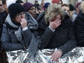 People wait outside the Madeleine church to attend Johnny Hallyday's funeral ceremony in Paris, France, Saturday, Dec. 9, 2017. France is bidding farewell to its biggest rock star, honoring Johnny Hallyday with an exceptional funeral procession down the Champs-Elysees, a presidential speech and a motorcycle parade -- all under intense security.