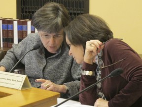 In this Wednesday, Dec. 20, 2017 photo, Kansas state Sen. Laura Kelly, left, D-Topeka, and state Rep. Kathy Wolfe Moore, right, D-Kansas City, confer during a committee briefing on a proposal to build a new state prison, at the Statehouse in Topeka, Kan. The briefing bolstered support for the project among top Republican lawmakers who will help decide whether the project moves forward.