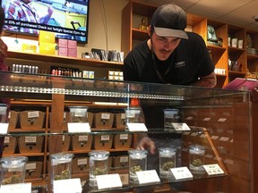 Torrey Holistics employee Taron McElroy arranges jars of cannabis in San Diego, Calif., Thursday, Dec. 14, 2017.  On Thursday, California issued its first batch of business licenses for the state's upcoming legal marijuana market, setting the stage for sales to begin to adults in January. The first license for recreational retail sales went to Torrey Holistics in San Diego.