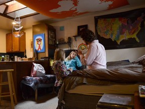 In this Tuesday, Nov. 28, 20017 photo, TC Bell sits with his two daughters Dagny, 8 and Emma, 4 before they get dressed for school, at their home in Denver. Bell's daughters are recipients of the Children's Health Insurance Program or CHIP, which is a program that provides low-cost coverage to families who earn too much to qualify for Medicaid. Arizona, California, Colorado, Minnesota, Ohio, Oregon and the District of Columbia are among the first expected to exhaust their CHIP allotments. (AP Photo/Tatiana Flowers)