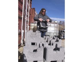 In this Nov. 21, 2017 photo, Meredith Comi of the NY/NJ Baykeeper environmental group lifts concrete cages that are submerged offshore to create oyster reefs at the Earle Naval Weapons Station in Middletown, N.J. Coastal communities around the world are planting oyster reefs to protect shorelines against the damaging effects of waves during storms, including the Navy pier that suffered $50 million worth of damage during Superstorm Sandy in 2012.
