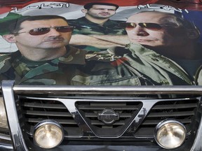 A car covered in a collage showing Russian President Vladimir Putin, right, Syrian President Bashar Assad, left, and President's Assad brother, Gen. Maher Assad, in Maarzaf, about 15 kilometers west of Hama, Syria.