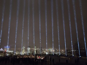 Fourteen beams of light shine toward the sky during a ceremony marking the 28th anniversary of the Montreal Massacre when a gunman shot 14 women to death and injured 14 other people, in Montreal on Wednesday, December 6, 2017.