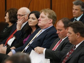 FILE - In an Oct. 24, 2017 file photo, South Carolina Rep Rick Quinn, center, sits with his wife, Amy McRae Benck, his parents, Richard Quinn, Sr. and Ruth LeJeune Quinn, left, and Matthew Richardson and Tracy Edge, right, during bond court in Columbia, S.C. Quinn is resigning Wednesday, Dec. 13, 2017, an hour before a hearing in a Statehouse corruption probe that has ensnared him along with several other lawmakers.