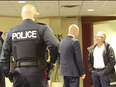 St. Catharines Standard reporter Bill Sawchuk, right, is addressed by Niagara Region senior staffer Chris Carter while being ejected from regional council chambers and removed from the property under police escort.