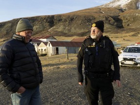 Police inspector Adolf Arnason talks with a local farmer living at the foot of Oraefajokull volcano in Iceland, Thursday, Nov. 30, 2017. The Oraefajokull volcano, dormant since its last eruption in 1727-1728, has seen a recent increase in seismic activity and geothermal water leakage that has worried scientists. With the snow hole on Iceland's highest peak deepening 18 inches (45 centimeters) each day, authorities have raised the volcano's alert safety code to yellow.