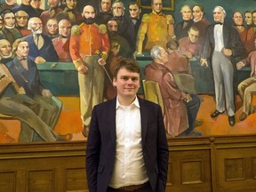 Andres Ingi Jonsson, a lawmaker for the Left Green Movement, poses for a photograph in front of a painting in parliament in Reykjavik, Friday, Dec. 1, 2017. The painting portrays a key moment in Icelandic history with only male politicians present. Feminists argue that today's  gender equality masks continuing violence, harassment and everyday sexism. Johnson is one of a group of male parliamentarians seeking to get men to become actively engaged in promoting gender equality.