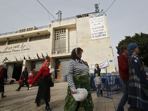 Tourists walk in Manger Square outside the Church of Nativity in Bethlehem, Tuesday, Dec. 19, 2017. In Jesus's traditional birthplace, sellers of holiday trinkets, roadside vendors and a leading hotelier say the protests that erupted after the U.S. President's provocative recognition of Jerusalem as Israel's capital have hurt their holiday business.