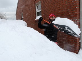 Patrick Harden clears snow from the roof of his car on Tuesday, Dec. 26, 2017, in Erie, Pa.
