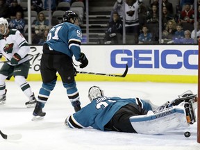 San Jose Sharks goalie Martin Jones, right, is beaten for a goal on a shot from Minnesota Wild's Ryan Murphy, left, during the first period of an NHL hockey game Sunday, Dec. 10, 2017, in San Jose, Calif.