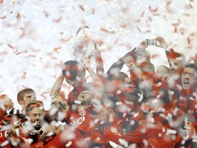 Toronto FC captain Michael Bradley hoists the trophy as his teammates celebrate their win over the Seattle Sounders in the MLS Cup final in Toronto on Saturday, Dec. 9, 2017.