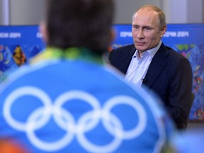 In this Jan. 17, 2014 file photo, Russian President Vladimir Putin speaks with Olympic volunteers in Sochi.