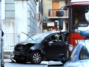 In this photo taken on Saturday, Dec. 9, 2017, the car that was driven into a pedestrian-only square seriously injuring a woman near an outdoor skating ring near the Sondrio market, Italy, before crashing into a pillar. Italian media say an Italian man who drove the car had been aiming to kill.