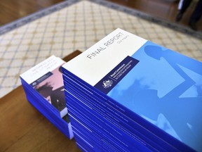 In this photo provided by the Australian Government Royal Commission, the volumes of the Final Report of the Royal Commission into Institutional Responses to Child Sexual Abuse sit on a table at Government House, in Canberra, Dec. 15, 2017. The commission delivered its final 17-volume report and 189 recommendations following a wide-ranging investigation.