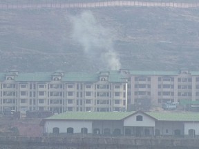 In this image made from video, smoke rises from a building inside a paramilitary camp in Lethpora, south of Srinagar, India Sunday, Dec. 31, 2017. Officials say a few gunmen entered the camp near southern Lethpora village early Sunday firing guns and grenades at the sentry. (AP Photo)