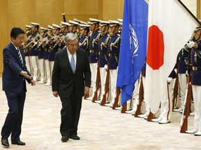 U.N. Secretary-General Antonio Guterres, second from left, is shown the way by Japanese Prime Minister Shinzo Abe while reviewing an honor guard before their meeting at Abe's official residence in Tokyo Thursday, Dec. 14, 2017.