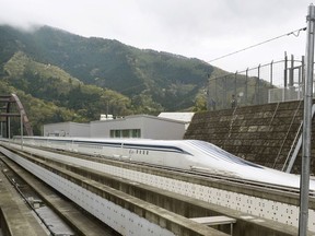 FILE - In this April 21, 2015, file photo, a Japanese maglev train that is the fastest passenger train in the world runs on the Maglev Test Line in Tsuru, west of Tokyo. Prosecutors raided the headquarters of several of Japan's biggest construction companies in an investigation into alleged collusion on bids for a multibillion dollar high-speed maglev train line. News reports Tuesday, Dec. 19, 2017 showed investigators heading into the headquarters of Taisei Corp. and Obayashi Corp., two of four companies targeted in the probe.