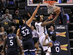 Memphis Grizzlies forward Jarell Martin (1) shoots against Minnesota Timberwolves center Karl-Anthony Towns (32), guard Jeff Teague (0) and center Gorgui Dieng (5)in the first half of an NBA basketball game Monday, Dec. 4, 2017, in Memphis, Tenn.