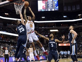 Atlanta Hawks forward John Collins (20) shoots against Memphis Grizzlies forward Chandler Parsons (25) as Grizzlies guard Andrew Harrison (5) and center Marc Gasol, right, move for position in the second half of an NBA basketball game Friday, Dec. 15, 2017, in Memphis, Tenn.