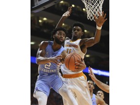 North Carolina guard Joel Berry II (2) is defended under the basket by Tennessee forward Kyle Alexander (11) in the first half of an NCAA college basketball game Sunday, Dec. 17, 2017, in Knoxville, Tenn.