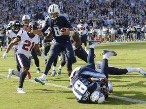 Tennessee Titans quarterback Marcus Mariota (8) leaps over tight end Jonnu Smith (81) as Mariota scores a touchdown on a 9-yard run against the Houston Texans in the first half of an NFL football game Sunday, Dec. 3, 2017, in Nashville, Tenn.