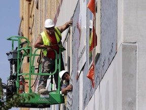 In this Friday, Oct. 6, 2017, photo, workers build an apartment and retail complex in Nashville, Tenn. On Wednesday, Dec. 6, 2017, the Labor Department issues revised data on productivity in the third quarter.