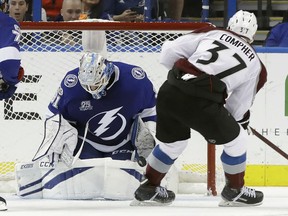 Tampa Bay Lightning goalie Peter Budaj (31) makes a save on a shot by Colorado Avalanche left wing J.T. Compher (37) during the second period of an NHL hockey game Thursday, Dec. 7, 2017, in Tampa, Fla.