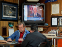 A newscast showing President Donald Trump plays on an old television set as customers play cards in the Frosty Freeze restaurant in Sandy Hook, Kentucky.