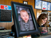 Chesla Whitt works in the Frosty Freeze restaurant she runs with her husband next to a picture of their nine-month old son, Tommy Joe.