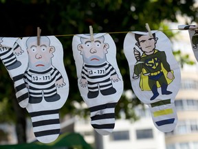 In this March 26, 2017 file photo, a set of inflatable dolls in the likeness of former President Luis Inacio Lula da Silva in prison garb and Judge Sergio Moro as a super hero, hang on a line for sale during a protest against corruption an in support of the Car Wash investigation on Copacabana beach, in Rio de Janeiro, Brazil. Marcelo Odebrecht, one of the most prominent people convicted in Latin America's largest corruption scandal left prison Tuesday, Dec. 19, for house arrest after serving two-and-a-half years behind bars at a time when many Brazilians are becoming disillusioned with the graft investigation once hailed as a political game-changer.