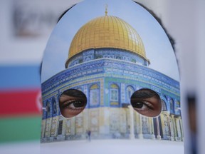 Protesters wearing masks with Jerusalem's Dome of the Rock Mosque, participate in a rally against U.S. President Donald Trump's decision to recognise Jerusalem at the capital of Israel, near the venue of Organisation of Islamic Cooperation's Extraordinary Summit in Istanbul, Wednesday, Dec. 13, 2017.