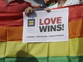 FILE - In this June 29, 2015, file photo, Supporters of the U.S. Supreme Courts ruling on same-sex marriage gather on the step of the Texas Capitol for a news conference celebrating marriage equality and looking to important work ahead in Austin, Texas. The U.S. Supreme Court on Monday, Dec. 4, 2017, has declined to step into a case over a Texas high court ruling that says gay spouses may not be entitled to government-subsidized workplace benefits.