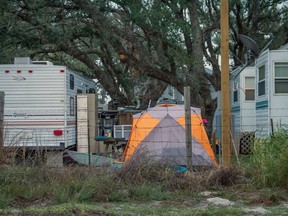 In this Dec. 15, 2017 photo provided by Kim Porter, shows people living in tents and trailers in Rockport, Texas. The federal government typically spends up to $150,000 apiece _ not counting utilities, maintenance or labor _ on the trailers it leases to disaster victims, then auctions them at cut-rate prices after 18 months of use or the first sign of minor damage. Officials have continued the practice even amid a temporary housing shortage in Texas, where almost 8,000 applicants are still awaiting federal support nearly four months after Hurricane Harvey landed in the Gulf Coast.