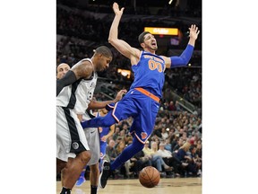 New York Knicks' Enes Kanter (00) falls after losing the ball to San Antonio Spurs' LaMarcus Aldridge during the first half of an NBA basketball game Thursday, Dec. 28, 2017, in San Antonio.