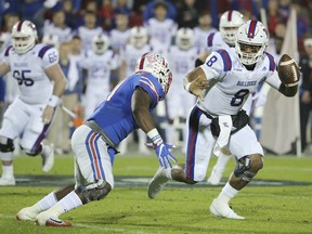 Louisiana Tech quarterback J'Mar Smith (8) attempts to avoid a tackle by SMU linebacker Kyran Mitchell (11) during the first quarter of the Frisco Bowl NCAA college football game Wednesday, Dec. 20, 2017, in Frisco, Texas.