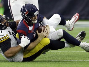 Houston Texans quarterback T.J. Yates (2) is tackled by Pittsburgh Steelers defensive end Cameron Heyward (97) during the first half of an NFL football game Monday, Dec. 25, 2017, in Houston.