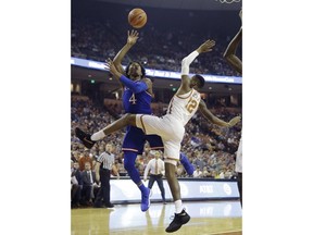 Kansas guard Devonte' Graham (4) shoots over Texas guard Kerwin Roach II (12) during the first half of an NCAA college basketball game Friday, Dec. 29, 2017, in Austin, Texas.