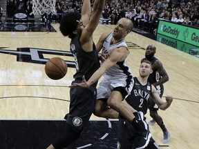 San Antonio Spurs guard Manu Ginobili, center, drives to the basket past Brooklyn Nets center Jarrett Allen, left, during the first half of an NBA basketball game, Tuesday, Dec. 26, 2017, in San Antonio.