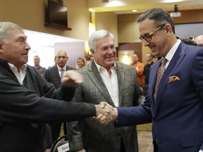 Chris Del Conte, right, visits with former Texas Athletic Director DeLoss Dodds, left, and former football coach Mack Brown, center, before a news conference where DelConte was introduced at the new vice president and athletics director for the University of Texas, Monday, Dec. 11, 2017, in Austin, Texas.