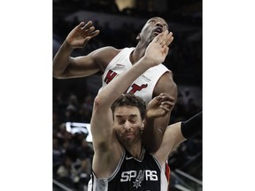 Miami Heat center Bam Adebayo, top, and San Antonio Spurs center Pau Gasol, bottom, jockey for position for a rebound during the first half of an NBA basketball game Wednesday, Dec. 6, 2017, in San Antonio.
